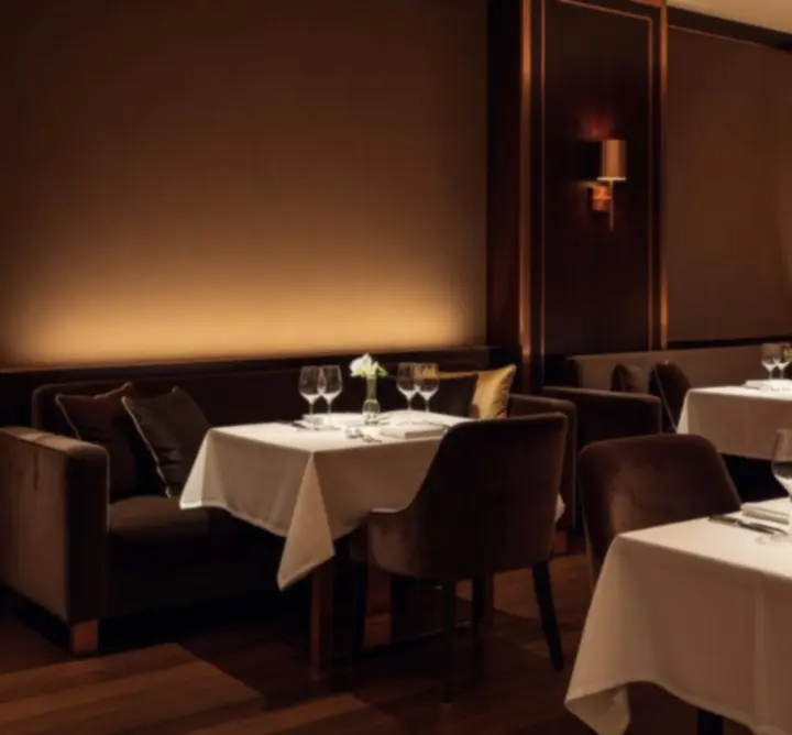 Elegancka sala restauracyjna w ciepłej palecie barw z luksusowym wystrojem.